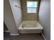 Bathroom highlighting a tiled bathtub, tile floors, and a window for natural light at 786 Crystal Bay Ln, Orlando, FL 32828