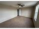 A carpeted bedroom with neutral walls, a ceiling fan, and natural light from a window at 786 Crystal Bay Ln, Orlando, FL 32828