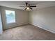 Bright bedroom with a ceiling fan, carpeted floor, and a window bringing in natural light at 786 Crystal Bay Ln, Orlando, FL 32828