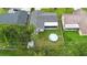 Aerial view of a home with a backyard pool, screened-in patio, and lush greenery surrounding the property at 10140 Bridlewood Ave, Orlando, FL 32825