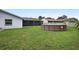 A spacious backyard featuring a lawn, screened patio, and above-ground pool for outdoor enjoyment at 10140 Bridlewood Ave, Orlando, FL 32825