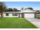 Inviting one-story home featuring a stone-accented garage and well-manicured lawn at 10140 Bridlewood Ave, Orlando, FL 32825