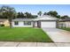 Charming one-story home with stone detail, green lawn, and mature palm tree at 10140 Bridlewood Ave, Orlando, FL 32825