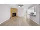 Spacious living room with modern ceiling fan, brick fireplace, and adjacent kitchen area at 10140 Bridlewood Ave, Orlando, FL 32825