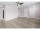 Open living room with wood-look floors, ceiling fan, and multiple entryways at 10140 Bridlewood Ave, Orlando, FL 32825