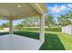 Covered back patio offers serene views of the manicured lawn and landscaping at 1018 Boxelder Ave, Minneola, FL 34715