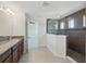 Bathroom featuring a granite countertop, double sink vanity, glass shower, and neutral tile flooring at 1018 Boxelder Ave, Minneola, FL 34715