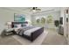 Elegant main bedroom featuring a large bed, tray ceiling with ceiling fan, and bright windows with backyard views at 1018 Boxelder Ave, Minneola, FL 34715