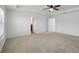 Spacious bedroom with neutral carpet, ceiling fan and doors to the bath and a walk-in closet at 1018 Boxelder Ave, Minneola, FL 34715