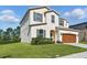 Charming two-story home with a well-maintained lawn, a two-car garage, and attractive architectural details at 1018 Boxelder Ave, Minneola, FL 34715