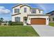 Charming two-story home with a well-maintained lawn, a two-car garage, and attractive architectural details at 1018 Boxelder Ave, Minneola, FL 34715