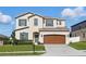 Charming two-story home with a well-maintained lawn, a two-car garage, and attractive architectural details at 1018 Boxelder Ave, Minneola, FL 34715