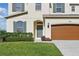 Charming two-story home with a well-maintained lawn, a two-car garage, and attractive architectural details at 1018 Boxelder Ave, Minneola, FL 34715