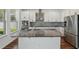 Modern kitchen with a large island, stainless steel appliances, and a mosaic backsplash at 1018 Boxelder Ave, Minneola, FL 34715