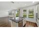 Open kitchen with island, stainless steel appliances, and natural light filtering through the windows at 1018 Boxelder Ave, Minneola, FL 34715