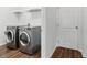 Modern laundry room with side-by-side appliances and wood-look tile floors at 1018 Boxelder Ave, Minneola, FL 34715