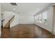 Open living room features wood-look flooring, staircase, recessed lighting, and multiple windows at 1018 Boxelder Ave, Minneola, FL 34715