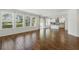 Bright living room with wood tile flooring and large windows, flowing into the modern kitchen at 1018 Boxelder Ave, Minneola, FL 34715