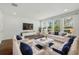 Bright living room featuring modern furniture, plush rug, and large windows at 1018 Boxelder Ave, Minneola, FL 34715