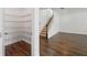 Spacious pantry with ample shelving adjacent to a staircase with wood flooring at 1018 Boxelder Ave, Minneola, FL 34715