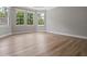 Bright bedroom featuring wood-look floors, gray walls, white trim, and multiple windows at 1106 Celebration Ave, Celebration, FL 34747