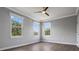 A bright bedroom featuring three large windows and a ceiling fan at 1106 Celebration Ave, Celebration, FL 34747