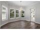 The dining room is filled with light from the large windows, which is reflected off the chandelier and hardwood floors at 1106 Celebration Ave, Celebration, FL 34747