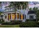 Charming two-story home featuring a covered porch, balcony, and manicured landscaping at sunset at 1106 Celebration Ave, Celebration, FL 34747
