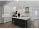 Elegant kitchen featuring a central island, stainless steel appliances, designer lighting, and ample cabinet storage at 1106 Celebration Ave, Celebration, FL 34747