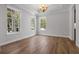 Spacious living room featuring hardwood floors, tray ceiling, a large window, and white trim at 1106 Celebration Ave, Celebration, FL 34747