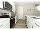 A modern kitchen with stainless appliances, white cabinets, stylish lighting, and quartz countertops at 12272 Bracco St, Winter Garden, FL 34787