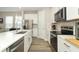 Bright kitchen boasts stainless steel appliances, sleek white cabinets, quartz countertops, and stylish pendant lighting at 12272 Bracco St, Winter Garden, FL 34787