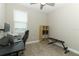 A home office space with a window view, carpet floors, black desk, and space for a workout bench at 12272 Bracco St, Winter Garden, FL 34787