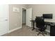 Carpeted office features a black computer desk, chair, and modern computer equipment with a doorway view at 12272 Bracco St, Winter Garden, FL 34787