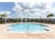 Spacious community pool with shallow end, lounge chairs, umbrellas, and lush palm trees at 12272 Bracco St, Winter Garden, FL 34787