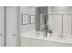 Elegant bathroom with a double vanity, modern fixtures, framed mirrors, and a glass-enclosed shower at 12954 Promise Pl, Orlando, FL 32832