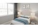 Bright bedroom with a large window, soft carpeting, and a comfortable bed with stylish linens at 12954 Promise Pl, Orlando, FL 32832