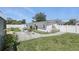 Private backyard with a white fence, lush green lawn, mature landscaping, a water fountain, and covered patio at 1325 Mcneil Rd, Altamonte Springs, FL 32714