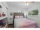 Bright bedroom featuring a tufted headboard, ceiling fan, and a window offering natural light at 1325 Mcneil Rd, Altamonte Springs, FL 32714