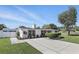 Beautifully landscaped white home with fresh green lawn, updated concrete driveway, and charming front bushes at 1325 Mcneil Rd, Altamonte Springs, FL 32714