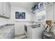 Well-lit laundry room featuring modern washer and dryer, stylish gray cabinetry, and neutral-toned flooring at 1325 Mcneil Rd, Altamonte Springs, FL 32714
