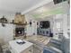 Cozy living room with stone fireplace, wood-look tile flooring, and neutral color scheme at 1325 Mcneil Rd, Altamonte Springs, FL 32714