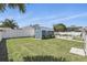 Backyard shed featuring a light blue exterior, white trim, well-maintained lawn, and white privacy fence at 1325 Mcneil Rd, Altamonte Springs, FL 32714