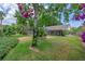 Lush backyard with a mature tree and swing provides a serene retreat with a screened-in porch at 1440 Suzanne Way, Longwood, FL 32779