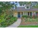 Charming home entrance featuring lush landscaping, a welcoming door, and classic architectural elements at 1440 Suzanne Way, Longwood, FL 32779