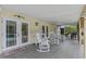 A covered patio with ceiling fan, tiled floor and rocking chairs are located near the pool at 1440 Suzanne Way, Longwood, FL 32779