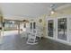Covered patio with ceiling fan, tiled floor, and rocking chairs overlooks fenced backyard and pool at 1440 Suzanne Way, Longwood, FL 32779