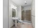 Full bathroom with tiled floors, toilet, pedestal sink and glass shower at 150 E Robinson St # 2807, Orlando, FL 32801