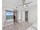 Bedroom with hardwood floors, large windows, mirrored closet, and view into bathroom at 150 E Robinson St # 2807, Orlando, FL 32801