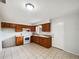 Traditional kitchen featuring wood cabinets, tile floor, and white appliances at 1543 Sarah St, Lake Wales, FL 33898
